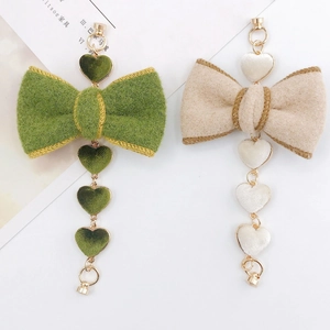 Detail of plush felt bow charms with velvet hearts for DIY jewelry and phone accessories