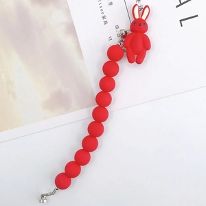Détail du bracelet en perles rouges mates avec pendentif lapin et fermoirs argentés