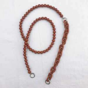 Close-up of caramel acrylic beads and resin chain strap with silver metal rings