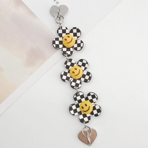 Détail de la chaîne de fleurs en damier avec smileys jaunes et breloques cœur en métal