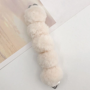 Detail of cream faux rabbit fur balls connected with silver heart-shaped metal clips