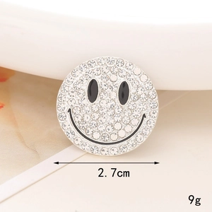 Close-up of 2.7cm smiley brooch with rhinestones and black enamel facial details