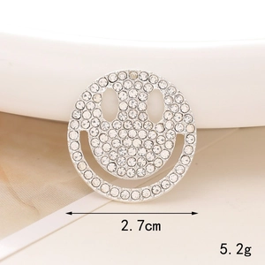 Macro shot of a 2.7cm rhinestone smiley face charm with silver metal base and pearls