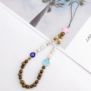 Bohemian phone charm detail with LOVE letter beads, evil eye accent and wood beads