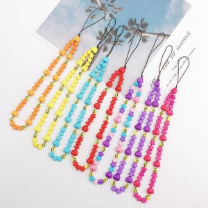 Colorful handmade beaded phone strap with star, heart and smiley face charms on a white stand