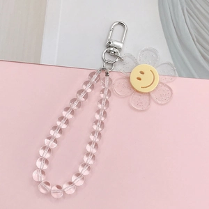Detail of beaded keychain charm with clear glitter beads and yellow smiley face flower