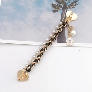 Detail of gold chain with black leather and white pearls for DIY accessories