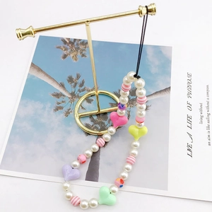Handmade beaded phone strap with colorful acrylic hearts and faux pearls on a gold stand