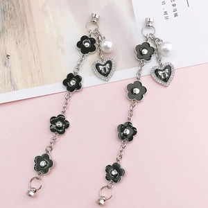 Détail de chaîne de téléphone fleurie avec perle et pendentif cœur en strass
