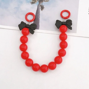 Détail de la lanière à perles rouges avec nœuds 3D noirs et anneaux pour sac ou mobile