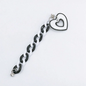 Detail of acrylic black and white thick chain link accessory with heart-shaped charms