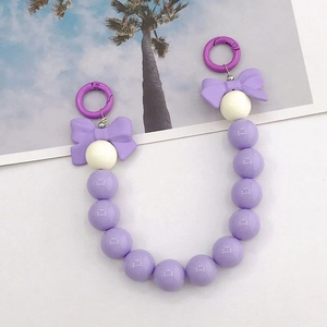 Détail de la dragonne en perles acryliques violettes avec nœud et crochet rond
