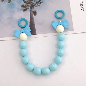Détail de la dragonne en perles acryliques bleues et beige avec nœuds et anneaux clips