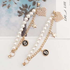 Dual-layer pearl and gold chain accessory with heart, star, and lucky number 5 charms