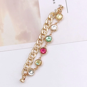 Close-up of double-layer gold chain bracelet with colorful gemstones and metal clasp