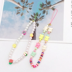 Detail view of colorful handmade beaded phone charms with cute resin bears and fruit beads