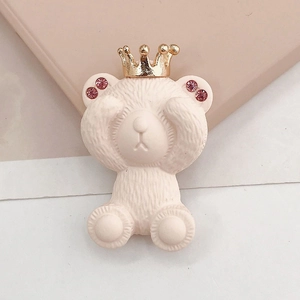 Détail d'une breloque ours rose avec couronne dorée et strass pour accessoires DIY