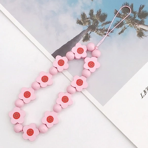 Detail view of pink floral beaded phone lanyard featuring resin flower and round beads