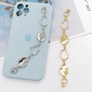 Detail of liquid metal style phone charms in gold and silver with glossy mirror finish
