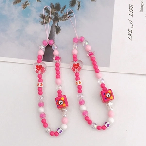 Detail of pink acrylic heart charms and beaded phone straps for mobile cases decoration