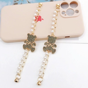 Golden pearl phone wrist strap featuring sparkling rhinestone bear charms and magnetic clasp