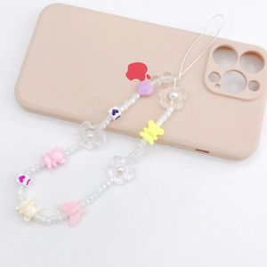 Acrylic bear and flower beaded phone strap with heart and butterfly charms on phone case