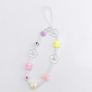 Detail of beaded phone strap with acrylic bears, flowers, and heart charms on white background