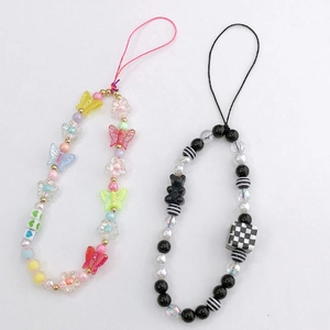 Detail of beaded phone straps with colorful butterflies and black and white bear charms
