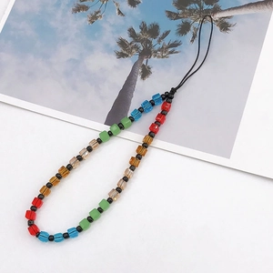 Close-up of colorful faceted square crystal beads on a black cord phone lanyard charm