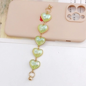 Detail of light green pearlescent heart charms with gold edges for phone case strap