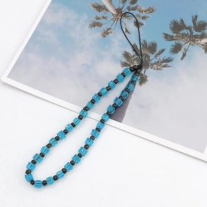 Detail shot of light blue crystal cube beads and black round beads on a phone strap charm