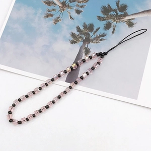 Detailed view of pink crystal beads and black spacer beads on a high-end phone wrist strap