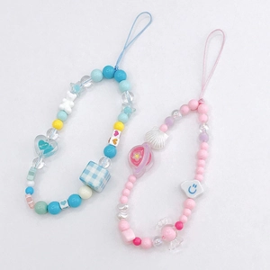 Detailed macro view of colorful handmade beaded phone charms with blue and pink themes