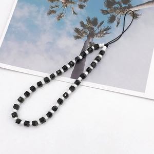 Elegant beaded phone strap with faceted black square beads and white spacers for wrist