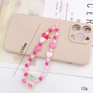 Detailed close-up of pink beaded phone charm with heart beads and cherry pendants