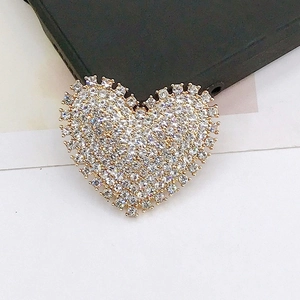 Macro detail of a golden heart brooch with sparkling rhinestones for DIY accessories