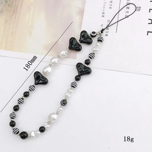 Beaded heart phone charm featuring black and white striped beads and faux pearls