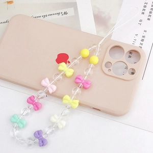 Détails rapprochés de perles en acrylique colorées et nœuds sur une lanière de téléphone