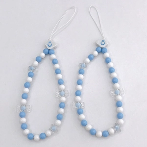 Close-up of blue and white beaded phone charms featuring a smiling cloud and star beads