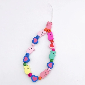 Detail of colorful wooden bear beads and heart charms on a handmade phone lanyard