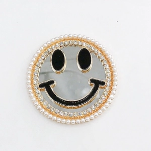 Detailed view of smiley face mirror phone grip with pearls and rhinestones