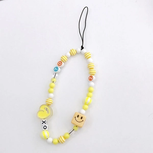 Detail of yellow beaded phone charm with colorful letter beads and a heart pendant