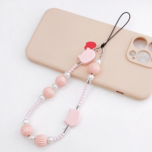 Pink beaded phone charm with cartoon pig beads and red heart pendant on a phone case
