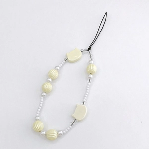 Detail of cream-colored beaded phone strap featuring cute cat-shaped charms and round beads