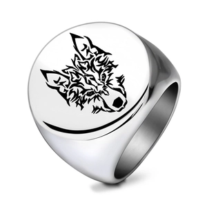 Gros plan d'une bague chevalière en acier inoxydable avec gravure de tête de loup noire