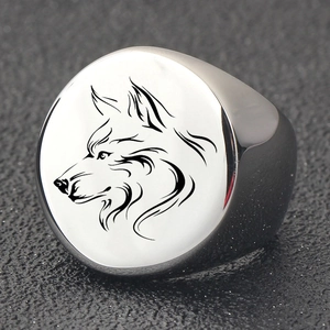 Vue macro de la bague chevalière en acier poli avec un motif de tête de loup gravé noir