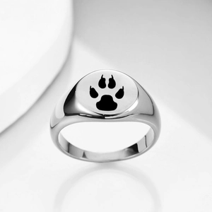 Detail of laser-engraved black paw print on a polished silver stainless steel ring