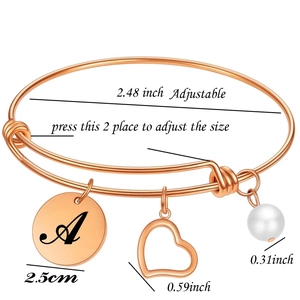 Détail du bracelet or rose ajustable avec cœur, perle et médaille gravée lettre A