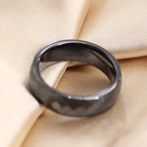 Detail macro-opname van een zwarte keramische ring op een gouden zijden achtergrond