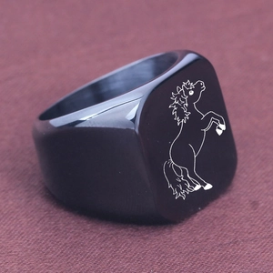 Detailed close-up of a black signet ring with a minimalist white laser-engraved horse